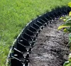 A black plastic garden edging product is installed between a lawn and a garden bed. Produktbild-Vorschau
