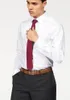 A man wearing a white dress shirt, red tie, and dark pants, with his hand on his tie. Produktbild-Vorschau