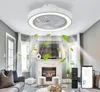 A modern ceiling fan with integrated lighting is shown in a living room setting. Green leaves are digitally superimposed to indicate air circulation. Náhľad obrázku produktu