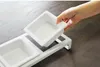 A hand is placing a white ceramic bowl into a white metal stand with two slots. Anteprima dell’immagine prodotto