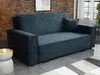 A blue corduroy sofa is shown in a room with a brick wall and a rug. Náhled obrázku produktu