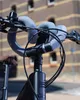A close-up view of a bicycle's handlebars, featuring a blue lock wrapped around them. Produktbild-Vorschau