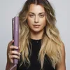 A woman is holding a hair straightener in front of her. Anteprima dell’immagine prodotto