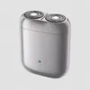 A silver electric shaver with two rotary heads is shown against a light gray background. Náhled obrázku produktu