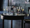 Champagne flutes filled with champagne and some strawberries on a table. Produktbild-Vorschau