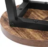 A close-up view of the underside of a stool, showing the connection between the metal frame and the wooden seat. Produktbild-Vorschau