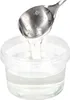 A spoon is lifting clear syrup from a plastic container. Produktbild-Vorschau