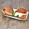 Two sandwiches on a white tray on a wooden surface. Produktbild-Vorschau