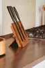 A wooden knife block with knives on a kitchen counter next to a stove. Produktbild-Vorschau