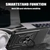 A black phone case with a ring holder is displayed on a textured surface, with a blurred background of a laptop and headphones. Produktbild-Vorschau