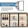 A white display cabinet with black aluminum frames and glass doors, showcasing various items like bottles, a clock, books, and decorative figures. Produktbild-Vorschau