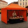A person standing behind a market stall decorated for Christmas. Voir les images du produit