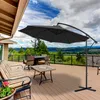 A patio deck with outdoor furniture and a large cantilever umbrella, overlooking a scenic landscape. Voir les images du produit