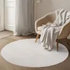 A round white rug in a living room setting, with a chair and blanket. Anteprima dell’immagine prodotto