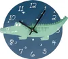 A cartoon-style wall clock featuring a green alligator on a dark blue background with numbers and decorative elements. Náhled obrázku produktu