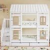 A white bunk bed shaped like a house with stairs and drawers, set against a light yellow wall. Anteprima dell’immagine prodotto