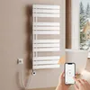 A modern bathroom with a white towel warmer, a bathtub, and a window showing a snowy landscape. A hand is holding a smartphone displaying a temperature control app. Produktbild-Vorschau