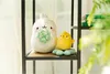 Two plush toys, a white rabbit and a yellow chick, are displayed on a shelf. Podgląd zdjęcia produktu