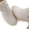 A close-up view of two light gray suede ankle boots with lace detailing on the left boot. Produktbild-Vorschau