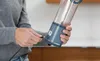 A person is holding a portable blender and plugging in a charging cable. Podgląd zdjęcia produktu