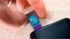 A hand is inserting a Kioxia EXCERIA 256 GB microSD card into a smartphone. Podgląd zdjęcia produktu