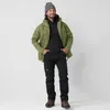A man wearing outdoor clothing stands against a white background. Produktbild-Vorschau