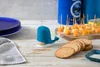 A whale-shaped toothpick dispenser sits on a wooden table next to crackers and cheese cubes on a cutting board. Náhled obrázku produktu