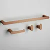 A set of copper-colored bathroom accessories mounted on a light gray wall. Produktbild-Vorschau