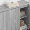 A close-up view of the interior and exterior of a gray wooden cabinet with books, a candle, and a radio on the shelves. Podgląd zdjęcia produktu