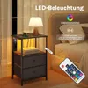 A bedside table with a lamp and books next to a bed. Produktbild-Vorschau