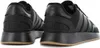 A close-up rear view of two black Adidas sneakers. Produktbild-Vorschau