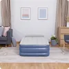 An inflatable air mattress is shown in a room with a sofa and a dresser. Náhled obrázku produktu