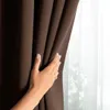 A hand is shown touching a dark brown curtain, with a blurred white curtain visible behind it. Podgląd zdjęcia produktu