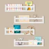 Four white wall shelves are mounted on a light brown wall, each displaying books and stuffed toys. Náhľad obrázku produktu