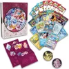 A collection of Pokemon trading cards, booster packs, stickers, and coins, arranged around a decorative box. Voir les images du produit