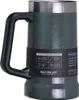 A close-up shot of a green Stanley thermal mug with a black handle, featuring a label with product information and features. Voir les images du produit