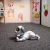 A toy robot dog is lying on a carpeted floor in a child's room. The room has colorful drawings on the wall. Náhľad obrázku produktu