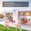 A security camera mounted on a house wall, with two children playing in the yard below. Red arrows indicate the camera's tracking motion. Produktbild-Vorschau