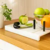 A kitchen counter with a cutting board, fruit, and a knife. Produktbild-Vorschau