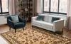 A living room scene with a sofa, armchair, and a rug. Produktbild-Vorschau