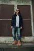 A man stands in front of a metal door. Produktbild-Vorschau