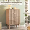 A wooden chest of drawers with decorative vertical slats, placed in a room with a light green wall and wooden floor. Decorative elements like a lamp and books are on top of the chest. Anteprima dell’immagine prodotto