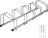 A bicycle rack with multiple slots for parking bicycles, shown on a white background. Screws and wall plugs are visible in the bottom right corner. Náhled obrázku produktu