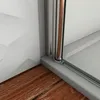 A close-up view of a shower enclosure corner, showing the frame, glass, and part of the shower tray, with wooden flooring in the foreground. Produktbild-Vorschau