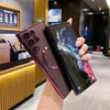 A person is holding two smartphones, one with a red case and the other a black smartphone, in what appears to be a cafe or retail environment. Náhled obrázku produktu