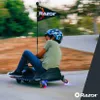 A child is riding a Razor Crazy Cart Shift Lightshow Lithium outdoors on a paved path. Produktbild-Vorschau