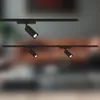 Two black track light fixtures are shown against a blurred background of a room. Produktbild-Vorschau