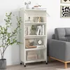 A white, multi-tiered storage cabinet with a plant and sofa in the background. Anteprima dell’immagine prodotto