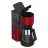 A red and black coffee maker with its lid open, shown from a slightly elevated angle against a white background. Náhled obrázku produktu