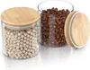 Two glass storage jars with bamboo lids, one filled with chickpeas and the other with coffee beans. A third lid is placed next to the jars. Náhled obrázku produktu